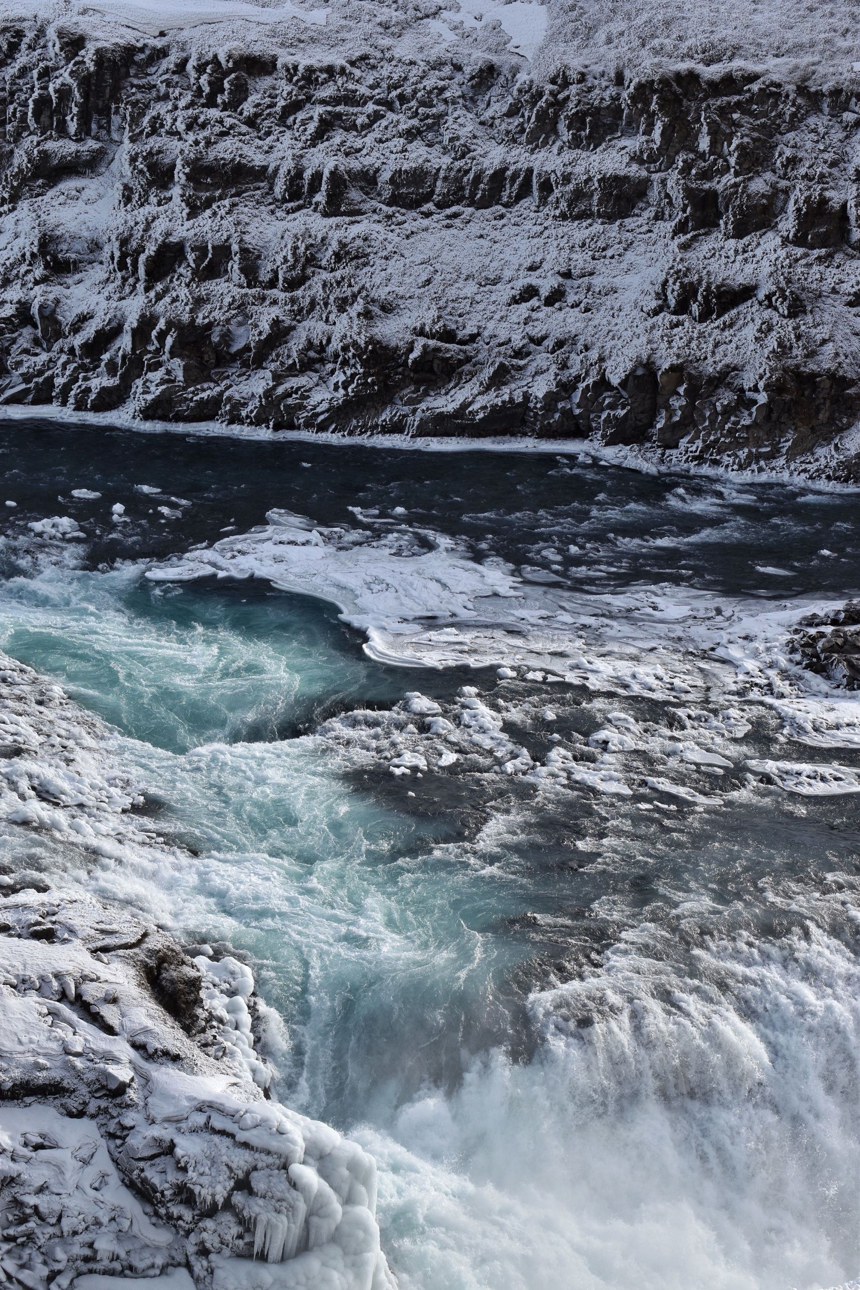 Gullfoss waterfall in winter, churning between snow-covered rocks