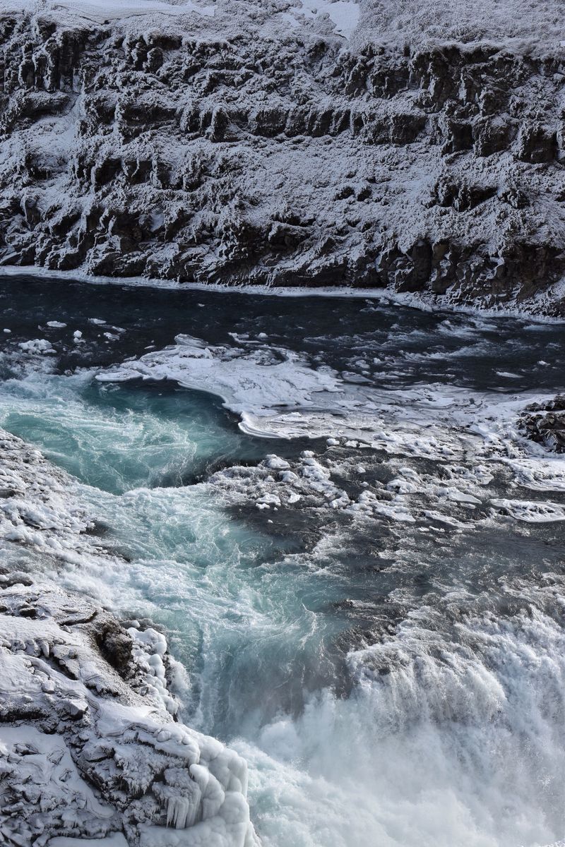 Gullfoss waterfall in winter, churning between snow-covered rocks