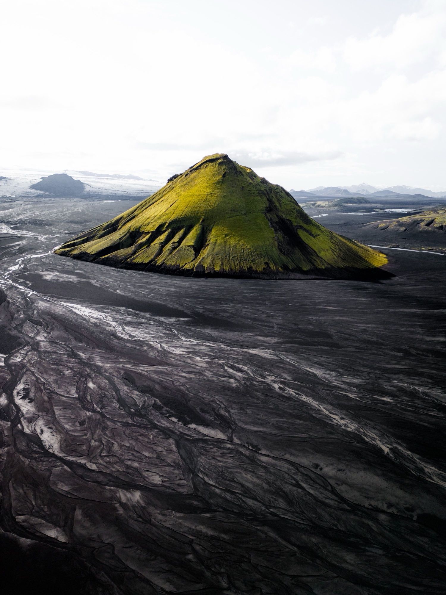 The moss-covered cone of Mælifell rising from black sand plains