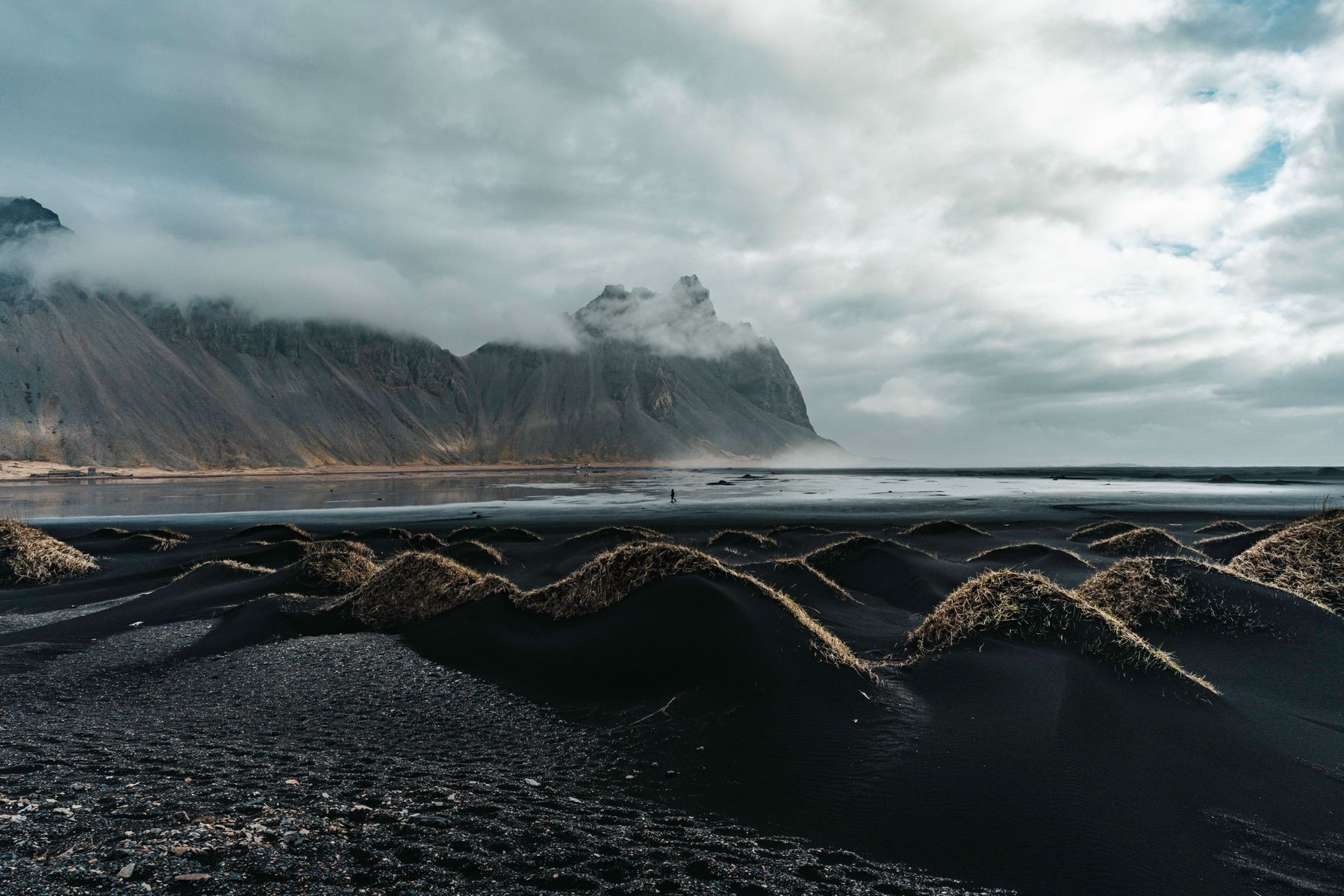 Clouds pouring over Vestrahorn above black dunes