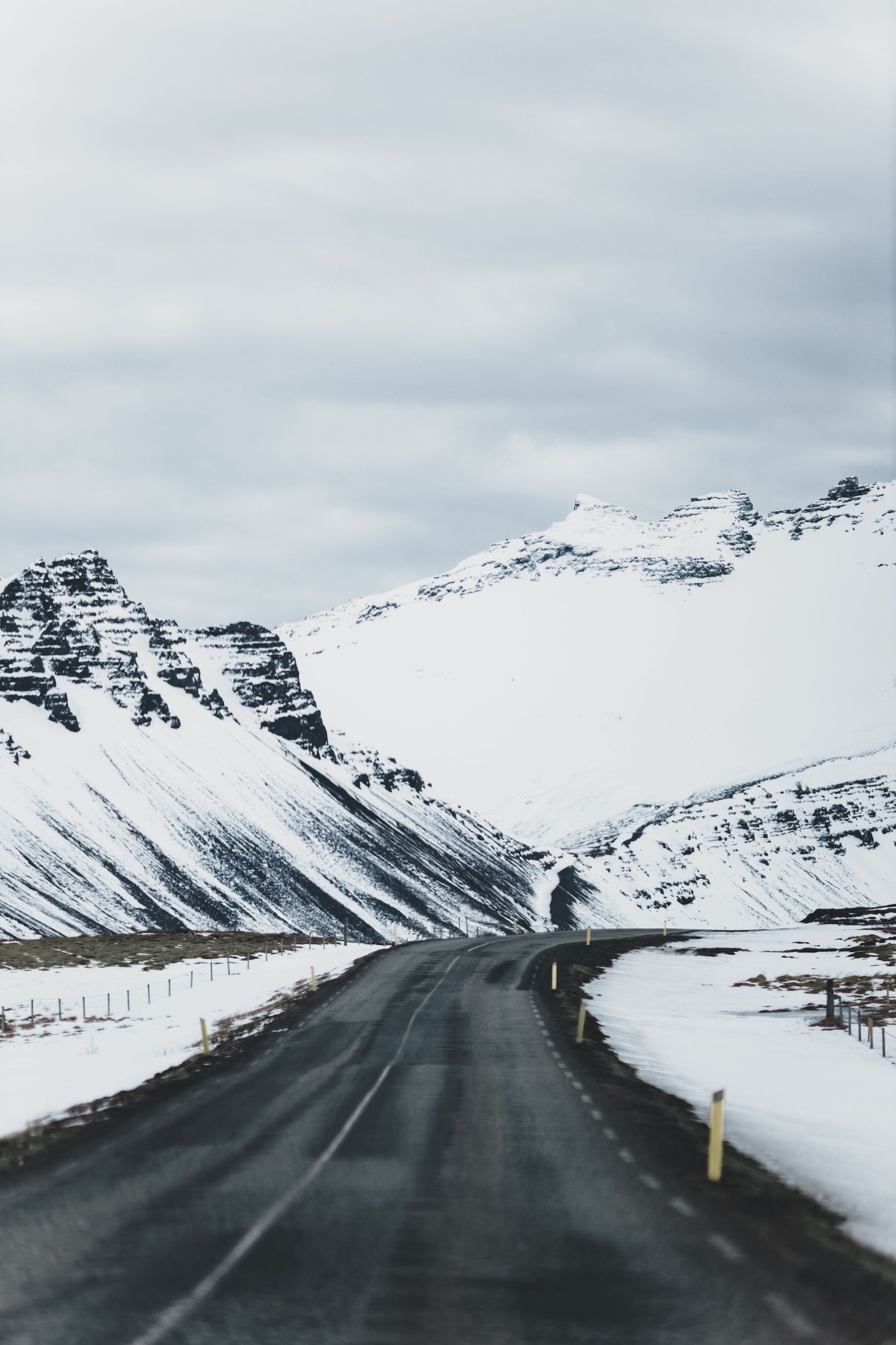The Ring Road winding between snow-covered mountains under a grey sky